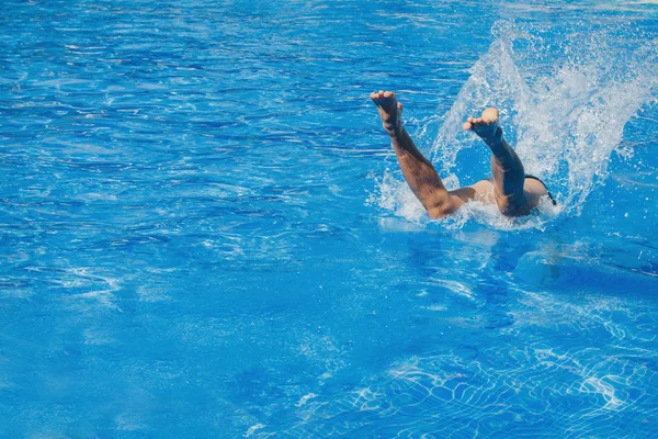 A man jumps into the pool. Swimmer in the water — Stock Photo, Image