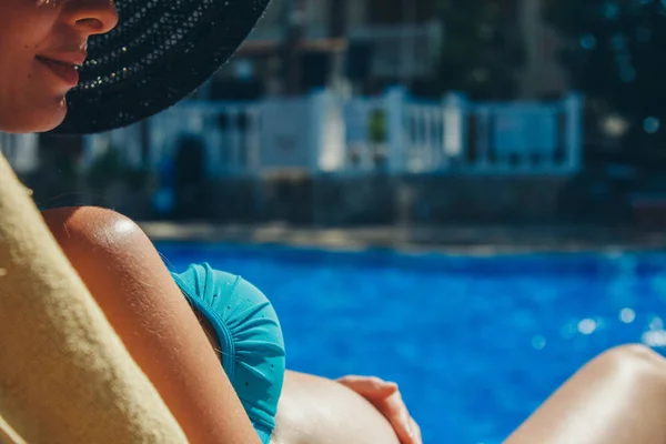 Mulher grávida tomando banho de sol em uma espreguiçadeira junto à piscina — Fotografia de Stock