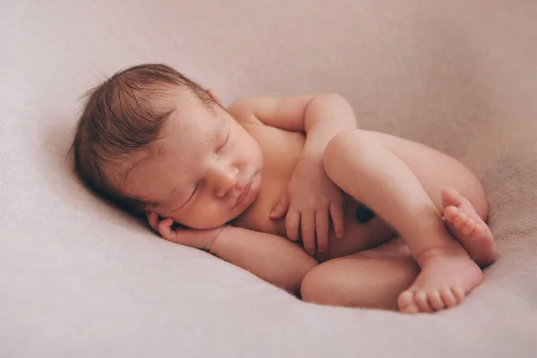 Naked newborn baby sleeping curled up in a ball — Stock Photo, Image