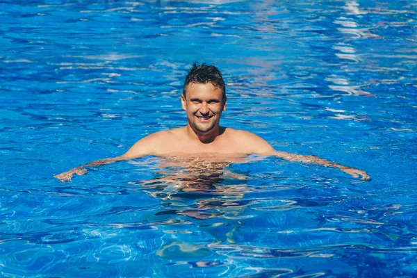 Hombre bronceado de vacaciones nadando en la piscina —  Fotos de Stock