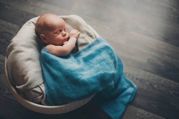 Pasgeboren baby gewikkeld in een deken slapen in een mandje — Stockfoto