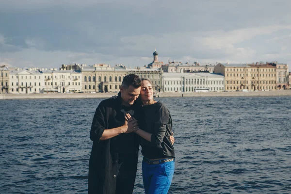 Seorang pria memeluk seorang gadis di latar belakang tepi pantai dan bangunan kuno — Stok Foto