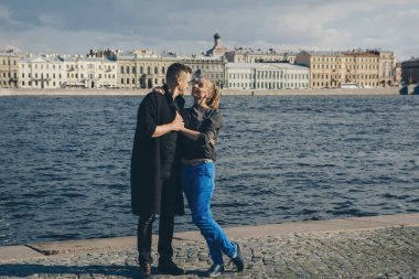 bir adam bir kız waterfront ve eski binalar arka plan üzerinde hugs.