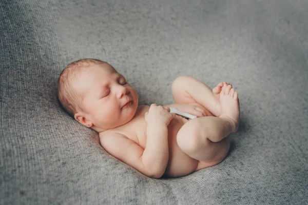 Naakte pasgeboren baby slapen opgerold in een bal — Stockfoto