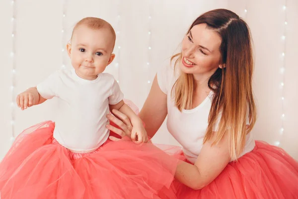 Baby in den Armen der Mutter. auf weißem Hintergrund eine Frau, die ein Kind hält. Mode für Mädchen. — Stockfoto