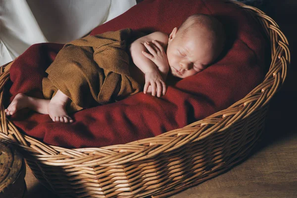 Bebé recién nacido envuelto en una manta durmiendo en una cesta — Foto de Stock