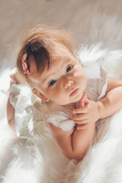 Niña pequeña con una cola en la cabeza arrastrándose por el suelo —  Fotos de Stock