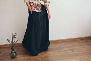 Japonca ve ayakkabı beyaz zemin üzerinde bir çiçek yanında keten giysiler içinde kadın ayakları