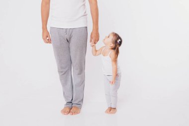Sevimli bebek yürümek ve ilk adımlarını yapmak öğrenme. Annem elini tutuyor. Çocuğun ayakları yakın yukarı, kopyalama alanı