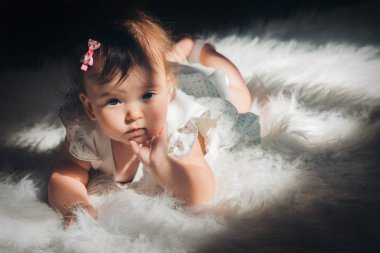 yerde sürünen başında bir kuyruklu küçük kız