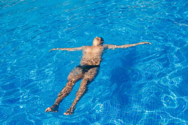 Tanned man on vacation swimming in the pool — Stock Photo, Image
