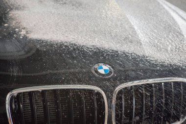 Araba tamir araba reklam araba yıkama, BMW reklam, Moskova, 1.11.2018: Siyah arabanın önünde BMW motor şirketi rozeti. Otomobil, motosiklet ve motor üretimi için BMW-Alman şirketi, foun