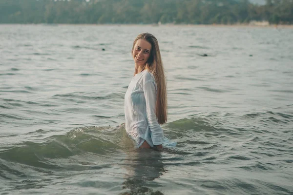 Girl with long hair in white shirt posing in water — Stock Photo, Image
