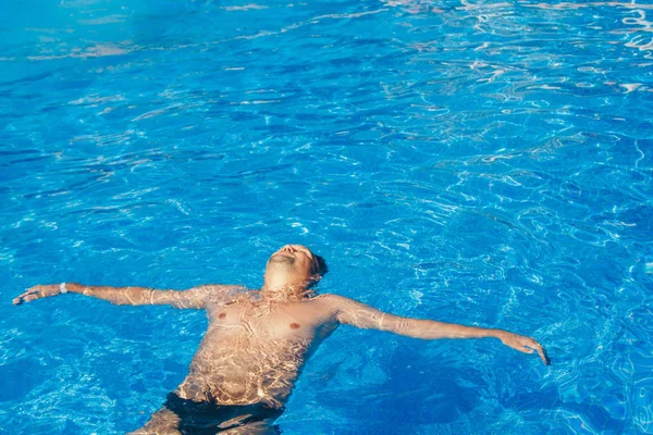 Garvade man på semester simning i poolen — Stockfoto