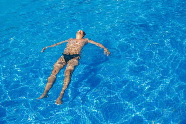 Gebruinde man op vakantie zwemmen in het zwembad — Stockfoto