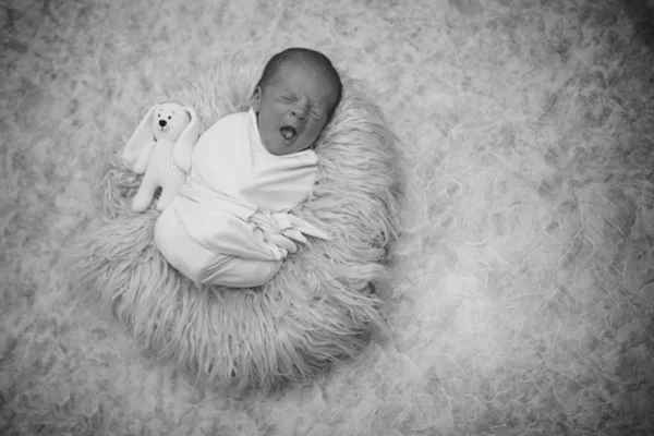 Bebé recién nacido envuelto en una manta durmiendo en una cesta —  Fotos de Stock