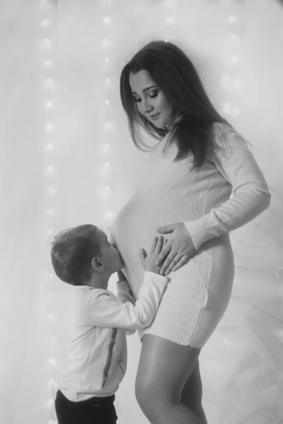 Ευτυχισμένο παιδί κορίτσι αγκάλιασμα της μητέρας έγκυος κοιλιά, την εγκυμοσύνη και νέα αντίληψη της ζωής — Φωτογραφία Αρχείου