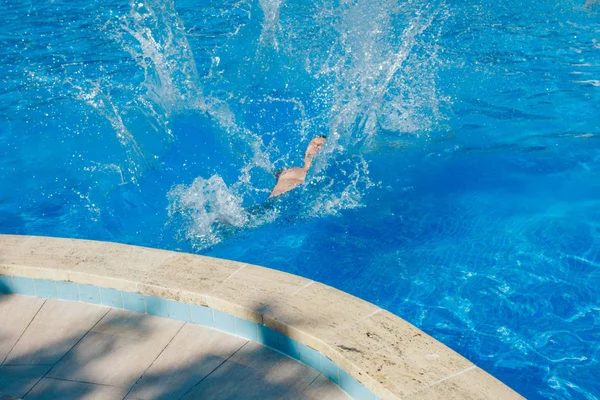 Ein Mann springt in den Pool. Schwimmer im Wasser Stockbild
