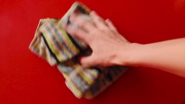 el çizgili bir bezle kırmızı yüzeyi siler