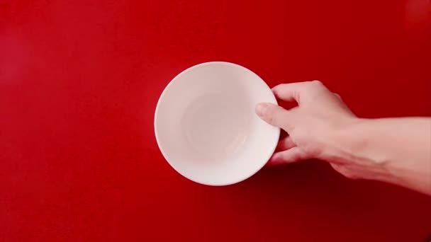 赤い背景に隔離 チョコレートボールは白いカップに注ぎ ミルクが注がれます おいしい朝食を準備する — ストック動画