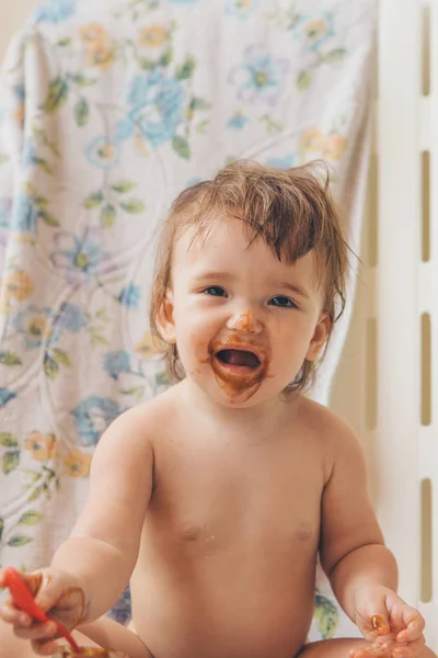 Retrato de uma criança que come comida de bebê de uma colher. Cara suja na comida — Fotografia de Stock