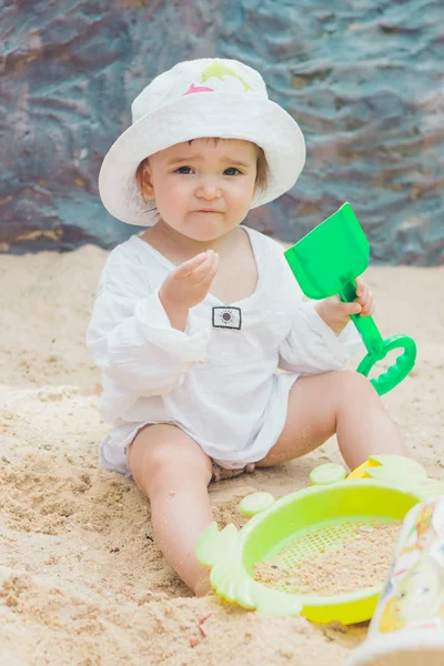 Petite fille assise dans le bac à sable et jouant avec le moule sur l'aire de jeux petit enfant jouant dans le sable — Photo