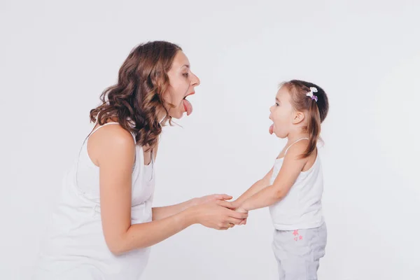 Мати і дочка показують один одному мову. Здоров'я та гігієна у жінок на білому тлі — стокове фото