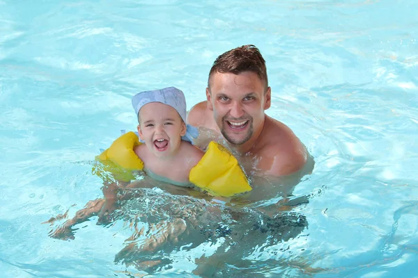 A man with a child swimming in the pool. Dad with daughter in the water — Stock Photo, Image