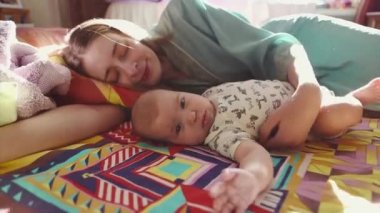 Mutlu anne ile onun yeni doğan uyuyan bebek yatakta yatarken, o hayran bebek, yavaşça vuruş ve onu öper.