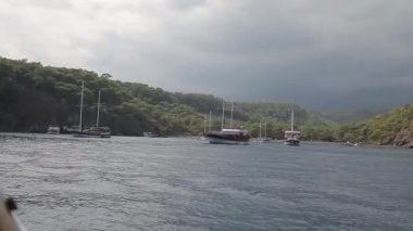 gemi denizde dalgalar üzerinde sallar. Gemiler için iskelesi olan bir koy. Okyanus ve gökyüzü ufku