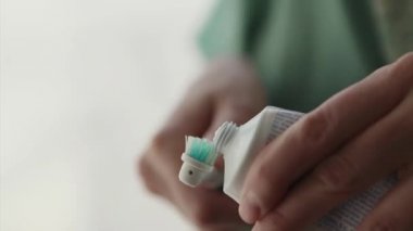 adam bir elektrik fırçası üzerinde tüp yapıştırın dışarı sıkar