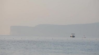 gemi denizde dalgalar üzerinde sallar. Gemiler için iskelesi olan bir koy. Okyanus ve gökyüzü ufku