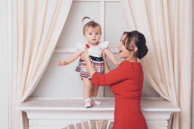 Sevimli bebek yürümek ve ilk adımlarını yapmak öğrenme. Annem elini tutuyor. Çocuğun ayakları yakın yukarı, kopyalama alanı