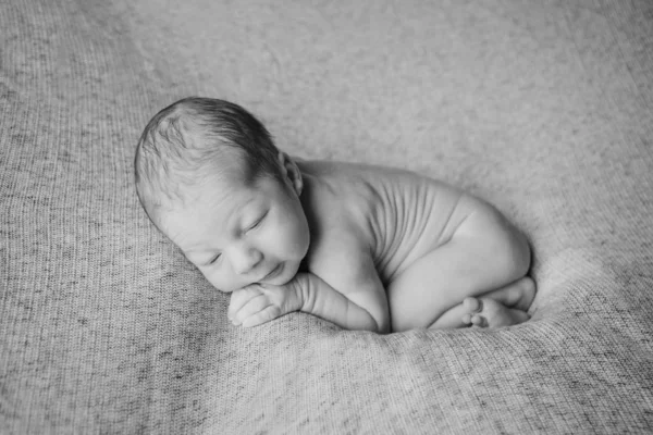 Naked newborn baby sleeping curled up in a ball — Stock Photo, Image