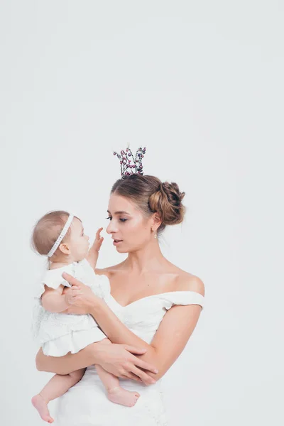 Baby in the arms of the mother. on white background Woman holding a child. Fashion for girl. Queen with princess — Stock Photo, Image