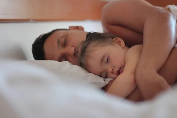 Dad hugs his daughter in a dream. A man and a child sleeping on white pillow