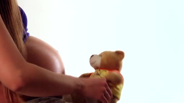 怀孕的妇女抱着 Teddybear 接近腹部玩耍 — 图库视频影像