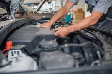 Araba tamir ve temizlik konsepti - araba motoru yakın çekim, kaputun altındaki parçaları silme