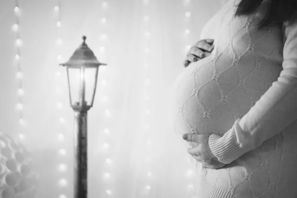 The concept of health, ECO - pregnant woman's stomach close-up. Girl stroking. Decorative lantern as background — Stock Photo, Image