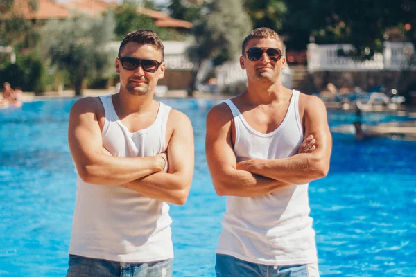 Koncepcja rekreacji, Turystyka-dwa uśmiechnięte zawyżone mężczyzn z okularami zabawy przy basenie — Zdjęcie stockowe