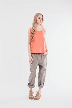 izole fotoğraf: uzun saçlı güzel model giysi kapalı gösterir. modelleme iş kavramı, gündelik giysiler