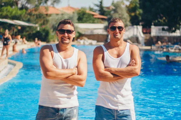 Koncepcja rekreacji, Turystyka-dwa uśmiechnięte zawyżone mężczyzn z okularami zabawy przy basenie — Zdjęcie stockowe