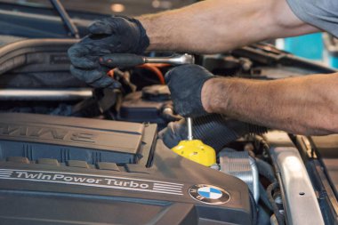 Reklam araba yıkama, Moskova, 1.11.2018: yüzey temizleme. Siyah arabanın önünde BMW motor şirketi rozeti. Alman şirketi. Araba tamir ve temizlik kavramı-motor yakın çekim, başlık altında parçaları silerek
