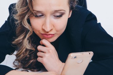 istihdam kavramı, röportajlar, dijital reklam - iş kadını yerde yatan telefon ekranına bakıyor. Beyaz arka planda izole edilmiş. Kopya alanı. Duyguları olan bir kadının portresi o