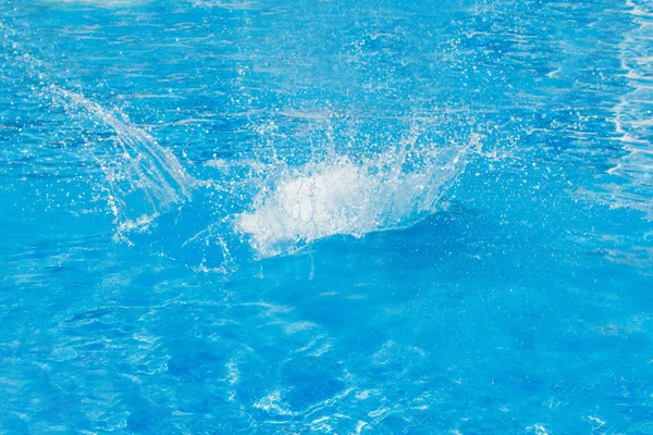 Spatten van blauw water in het zwembad close-up. ruimte kopiëren — Stockfoto