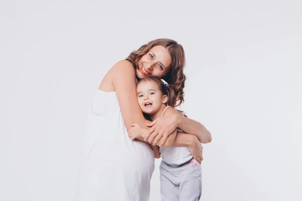 Mom and daughter having fun on a white background. Pregnant woman and child play together. concept of childhood, healthcare, IVF — Stock Photo, Image