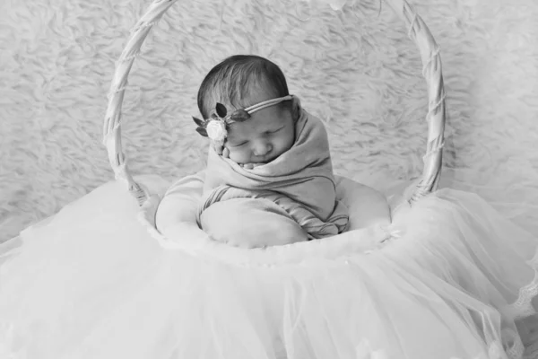 Newborn baby with a flower on his head, wrapped in a blanket, sleeping in a basket. the concept of childhood, health, IVF — Stock Photo, Image