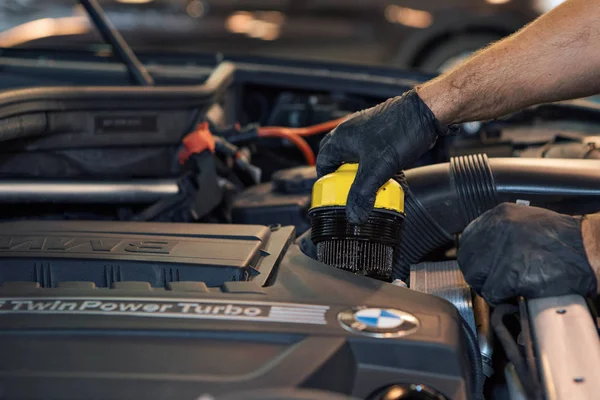Reklam araba yıkama, Moskova, 1.11.2018: yüzey temizleme. Siyah arabanın önünde BMW motor şirketi rozeti. Alman şirketi. Araba tamir ve temizlik kavramı-motor yakın çekim, başlık altında parçaları silerek