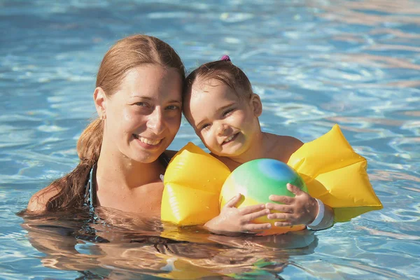 Mère et fille dans les accoudoirs pour nager en vacances dans la piscine. Le concept de Spa, cours de natation, vacances, traitement de l'eau — Photo