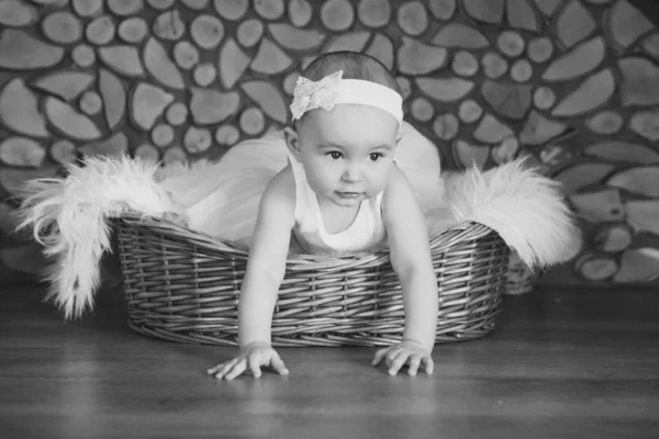 Дівчина в сукні сидить у кошику на білому дровах. концепція свята, веселощів, домашнього затишку — стокове фото